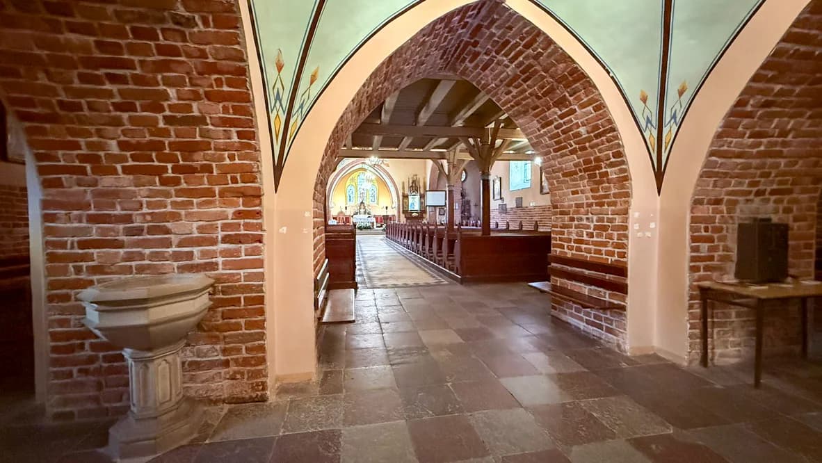 Ceglane arkady kościoła św. Anny i kamienna misa przy wejściu do nawy